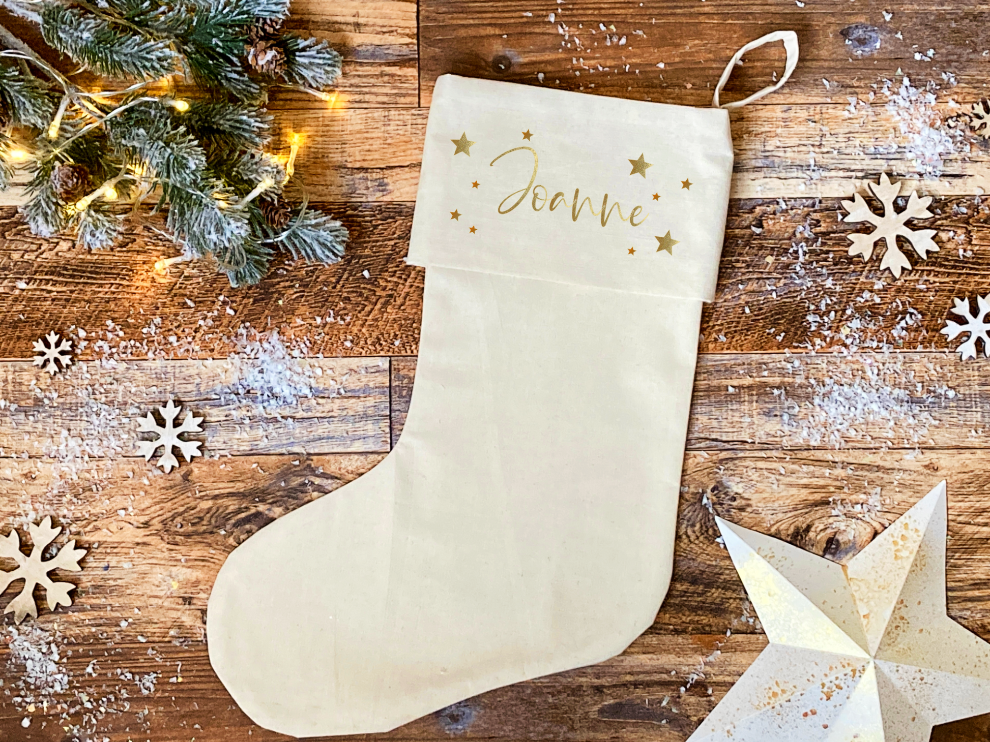 a plain calico christmas stocking, personalised with a name and decorated with gold stars